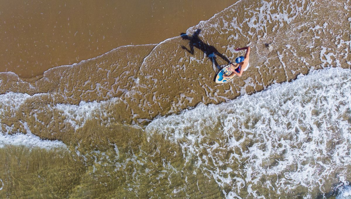 Overhead shot of a skimboarder in the surf